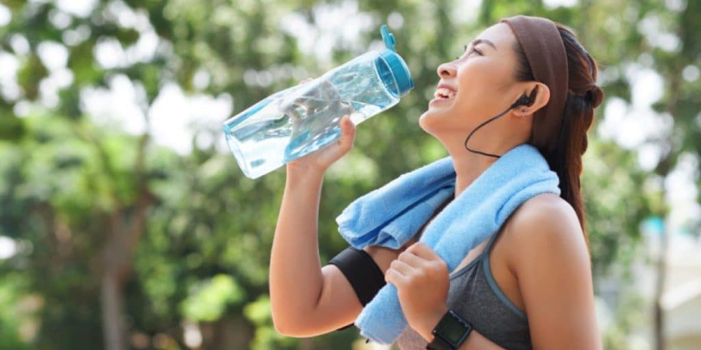 Mulher bebendo água após atividade física