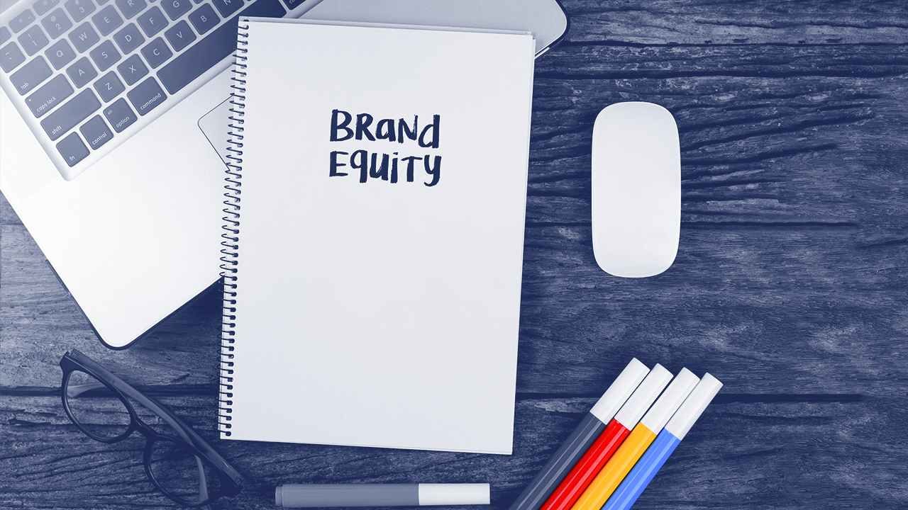 Um caderno em cima de uma mesa com o termo de Brand Equity escrito.